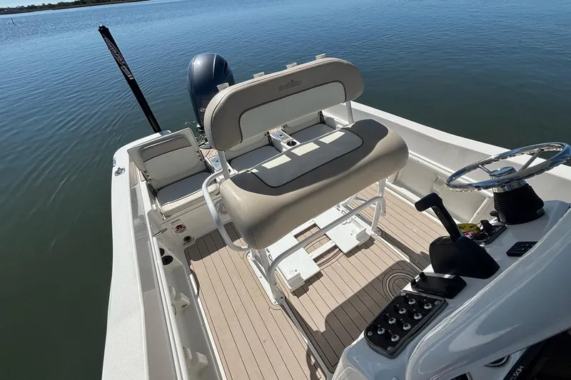Slide: The Image of 2016 NauticStar 231 Coastal boat interior with steering wheel and seating on calm water. - 8