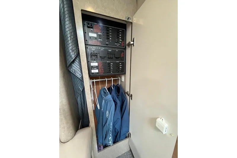 Slide: The Image of Electrical panel and hanging jackets inside a 2005 Formula 37 Performance Cruiser cabinet. - 54