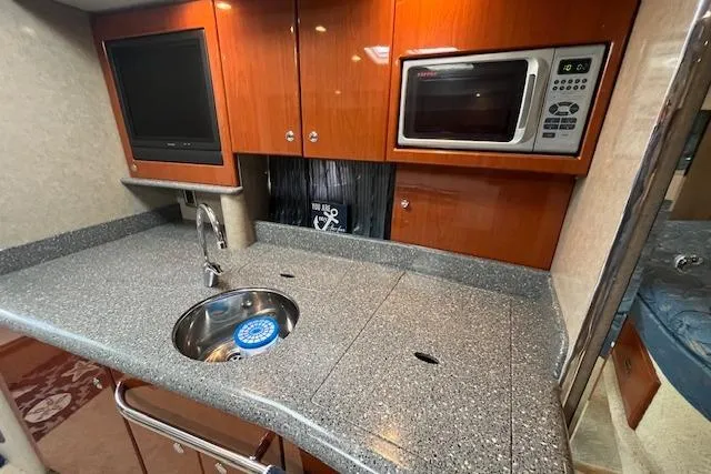 Slide: The Image of 2005 Formula 37 Performance Cruiser kitchen with sink, microwave, and TV. - 57