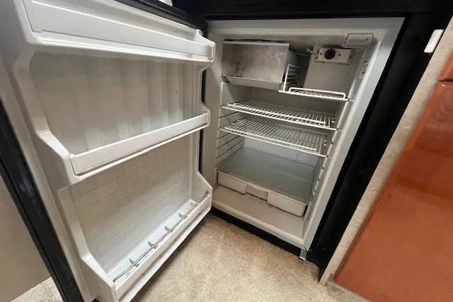 Slide: The Image of Open refrigerator inside a 2005 Formula 37 Performance Cruiser, showing empty shelves and compartments. - 60