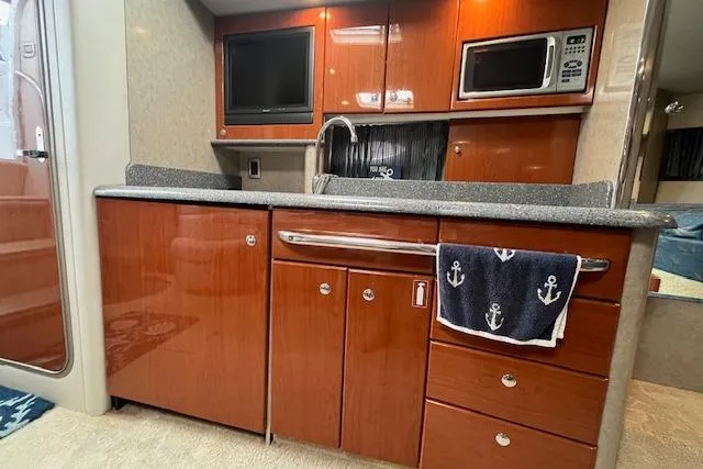 Slide: The Image of 2005 Formula 37 Performance Cruiser kitchen with wood cabinetry, microwave, and sink. - 61