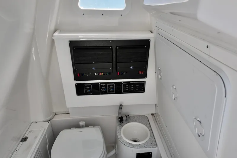 Slide: The Image of Interior of 2026 Sea Fox 282 Hybrid LT boat featuring control panel and compact bathroom amenities. - 19