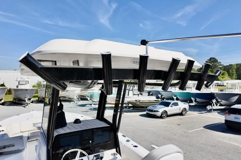 Slide: The Image of 2026 Sea Fox 282 Hybrid LT boat with rod holders, parked in a marina under clear skies. - 28
