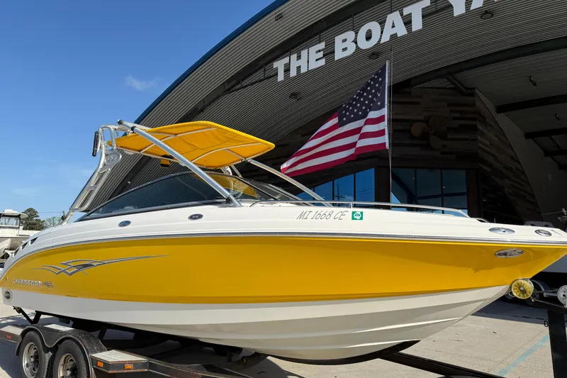 Slide: The Image of 2008 Chaparral 236 SSX boat with yellow hull, displayed at a marina. - 3