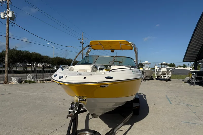Slide: The Image of 2008 Chaparral 236 SSX boat with yellow hull on trailer, parked outdoors. - 4