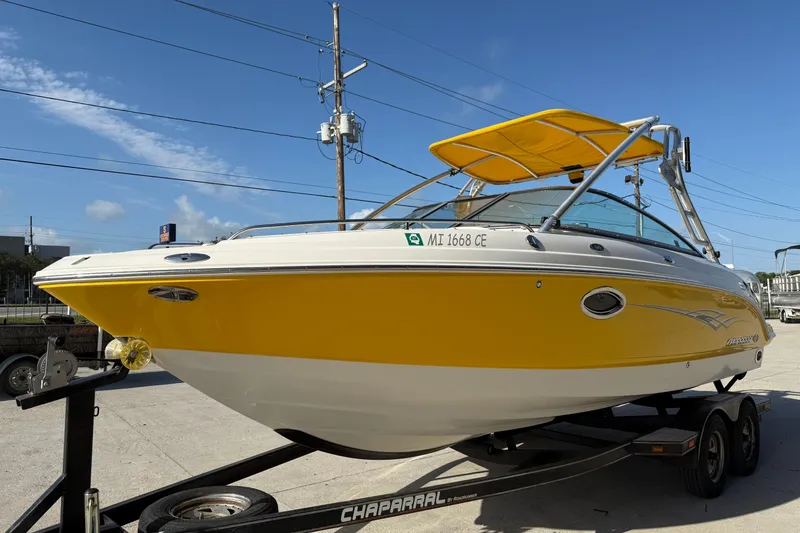 Slide: The Image of 2008 Chaparral 236 SSX boat with yellow hull on trailer, sunny day background. - 5