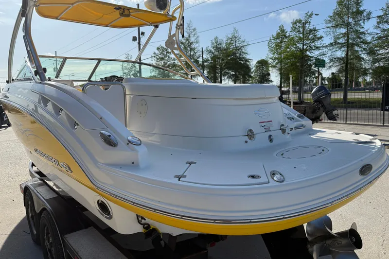 Slide: The Image of 2008 Chaparral 236 SSX boat with yellow accents, parked on a trailer. - 8