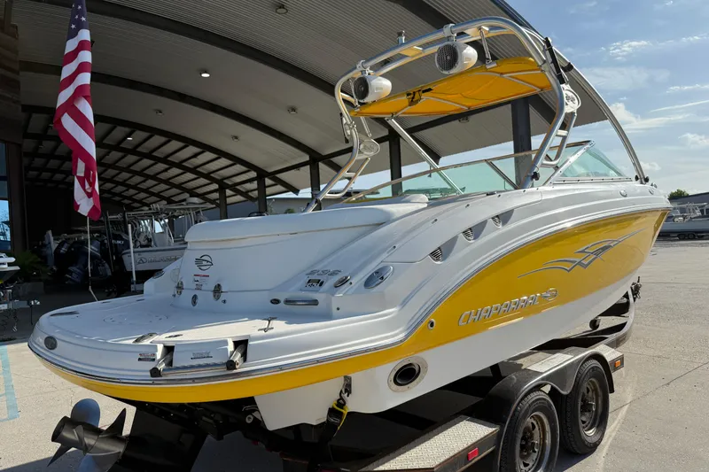 Slide: The Image of 2008 Chaparral 236 SSX boat with yellow accents on a trailer, under a canopy. - 9