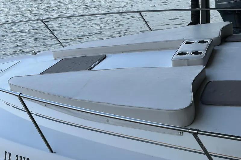 Slide: The Image of 1997 Sea Ray Sundancer 330 boat deck with cushioned seating and cup holders. - 14