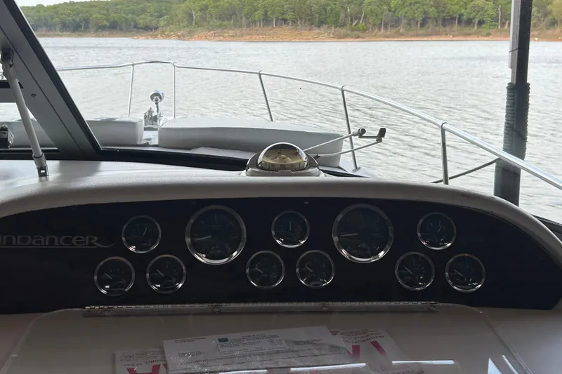 Slide: The Image of 1997 Sea Ray Sundancer 330 dashboard view with lake in the background. - 23