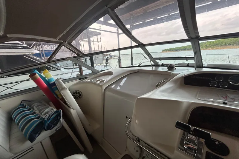 Slide: The Image of 1997 Sea Ray Sundancer 330 cockpit with lake view, featuring helm controls and seating. - 26