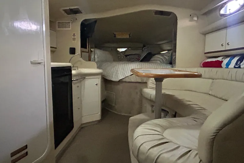 Slide: The Image of Interior of 1997 Sea Ray Sundancer 330, featuring cozy seating and compact kitchenette. - 28