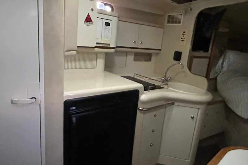 Slide: The Image of 1997 Sea Ray Sundancer 330 interior kitchen with sink, microwave, and storage cabinets. - 29