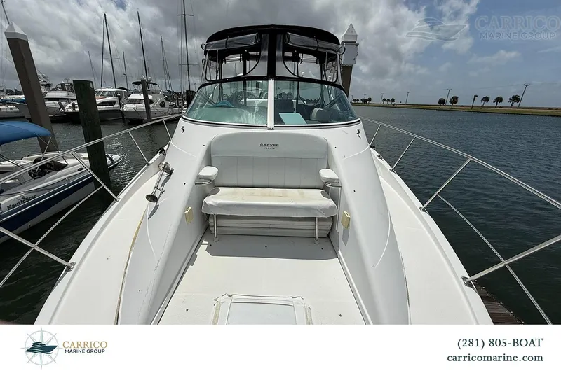 Slide: The Image of 2000 Carver 350 Mariner yacht docked at marina, featuring spacious deck seating. - 13