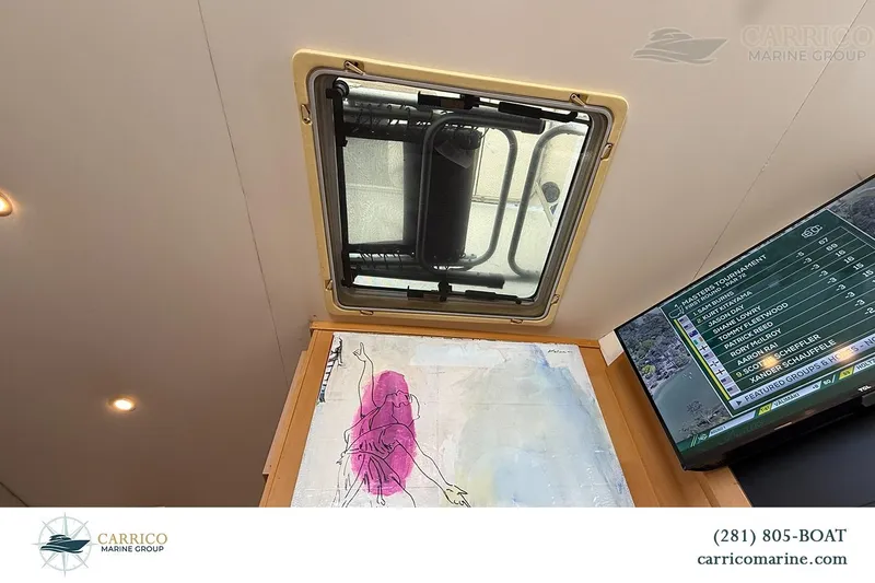 Slide: The Image of Interior view of a 2000 Carver 350 Mariner with a ceiling hatch and TV display. - 36