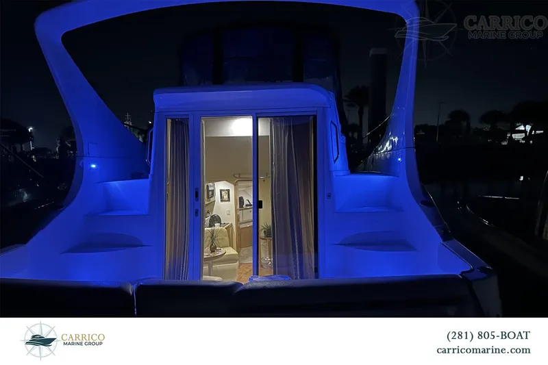 Slide: The Image of 2000 Carver 350 Mariner yacht illuminated at night, showcasing interior through glass doors. - 37