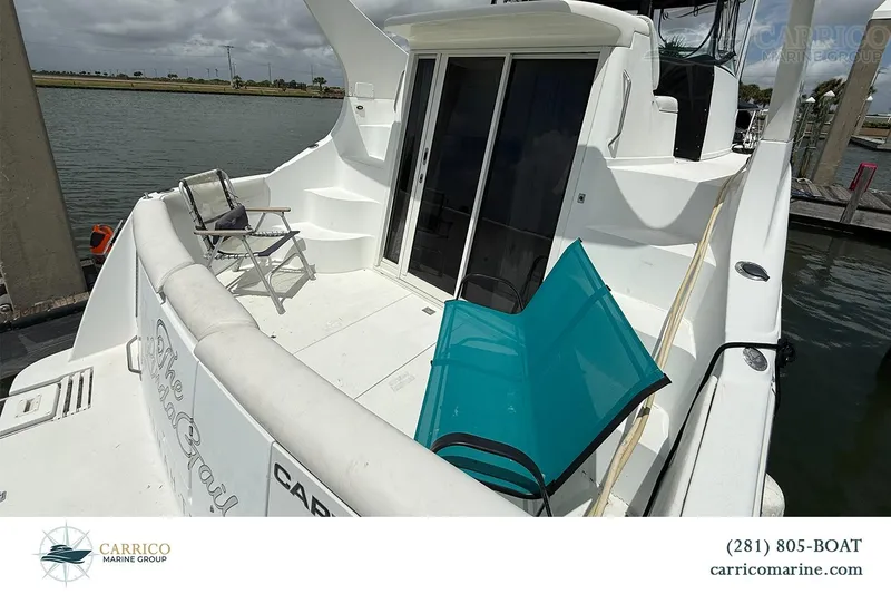 Slide: The Image of 2000 Carver 350 Mariner yacht deck with chairs, docked by the water. - 9