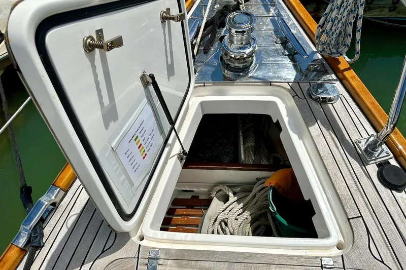 Slide: The Image of Open hatch on 2012 Hylas 56 yacht deck, revealing storage with ropes and equipment. - 12
