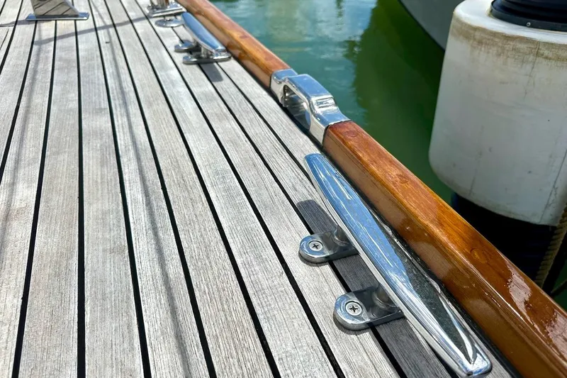 Slide: The Image of Teak deck of 2012 Hylas 56 yacht with polished metal cleats. - 14