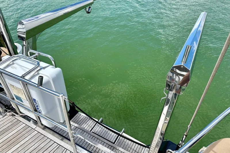 Slide: The Image of Stern view of 2012 Hylas 56 yacht with stainless steel davits over green water. - 16