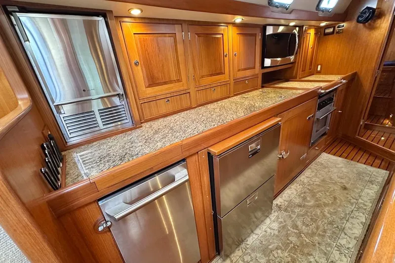 Slide: The Image of Luxurious 2012 Hylas 56 yacht kitchen with wood cabinetry and stainless steel appliances. - 23