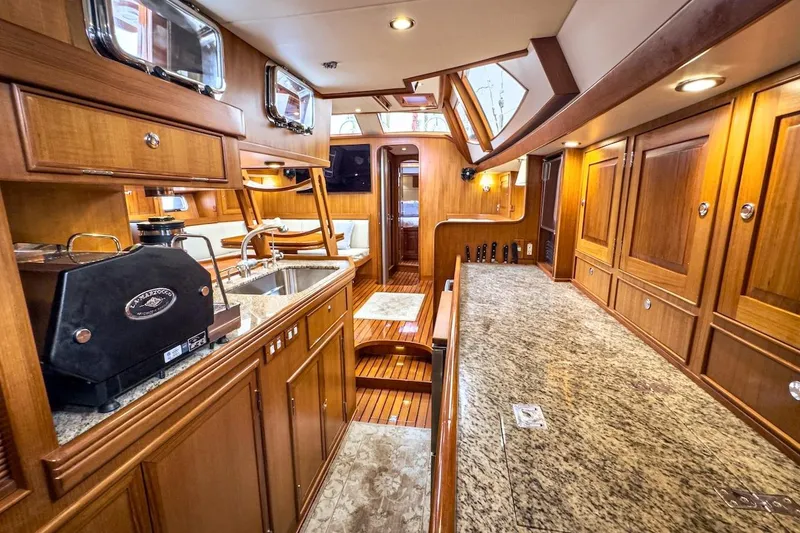 Slide: The Image of Luxurious interior of a 2012 Hylas 56 yacht featuring elegant wood cabinetry and granite countertops. - 25