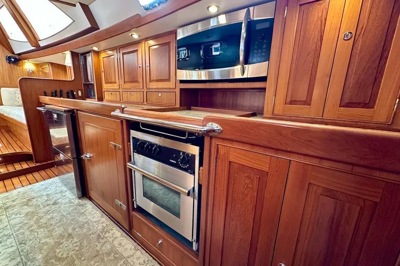 Slide: The Image of Luxurious wooden interior of a 2012 Hylas 56 yacht kitchen with modern appliances. - 26