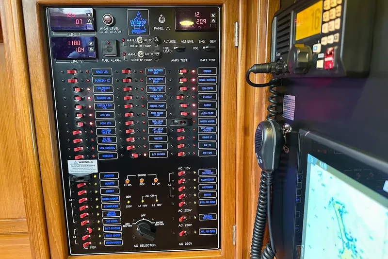 Slide: The Image of Electrical control panel on a 2012 Hylas 56 yacht, featuring switches and displays. - 34