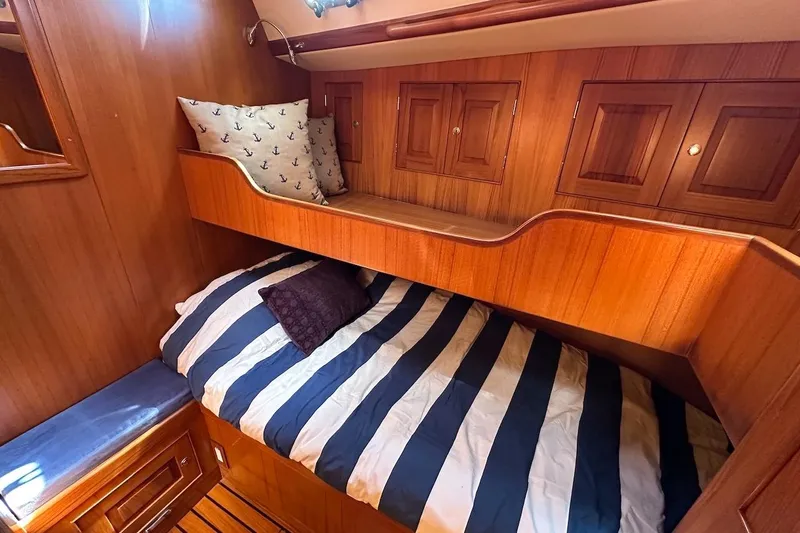 Slide: The Image of Cozy cabin interior of 2012 Hylas 56 yacht with striped bedding and wooden finish. - 37