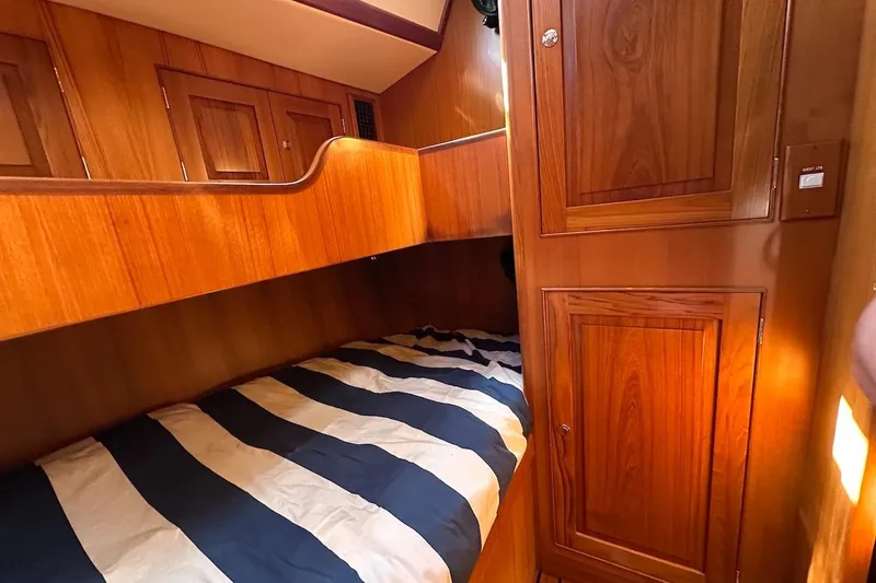 Slide: The Image of Cozy wooden cabin interior of 2012 Hylas 56 yacht with striped bedding. - 38