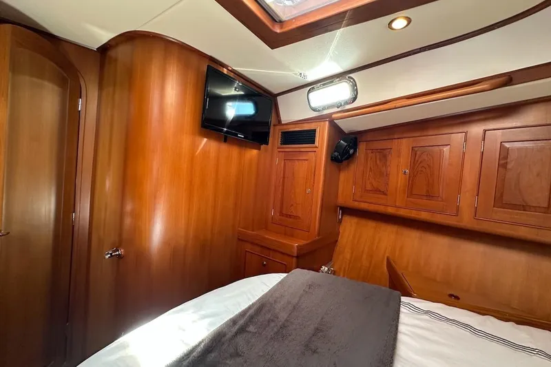 Slide: The Image of Luxurious wooden interior of a 2012 Hylas 56 yacht cabin with TV and storage. - 40