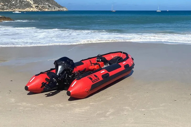 Slide: The Image of Red inflatable boat on sandy beach with ocean backdrop, Hylas 56 model, 2012. - 49