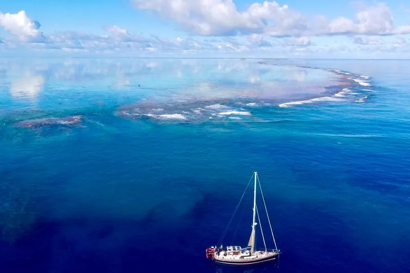 Slide: The Image of Sailboat Hylas 56 (2012) on serene blue ocean near coral reef under cloudy sky. - 5