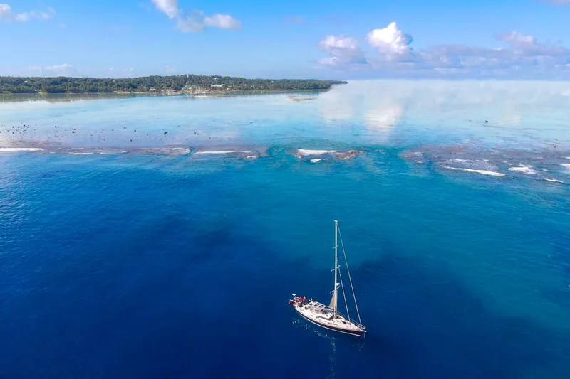 Slide: The Image of Sailboat Hylas 56 (2012) cruising in clear blue ocean near tropical coastline. - 6
