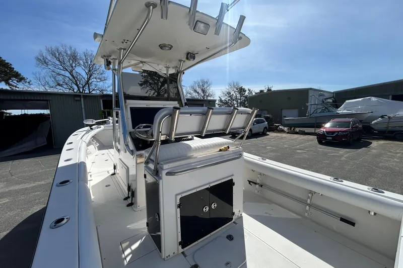 Slide: The Image of 2006 Albin 26 Center Console boat with seating and storage, parked outdoors under clear skies. - 11
