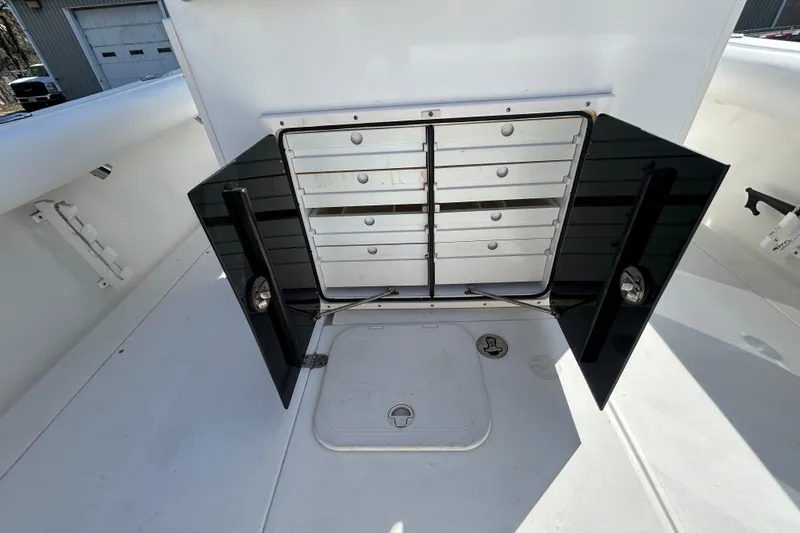 Slide: The Image of 2006 Albin 26 Center Console boat storage compartment with open black doors. - 12