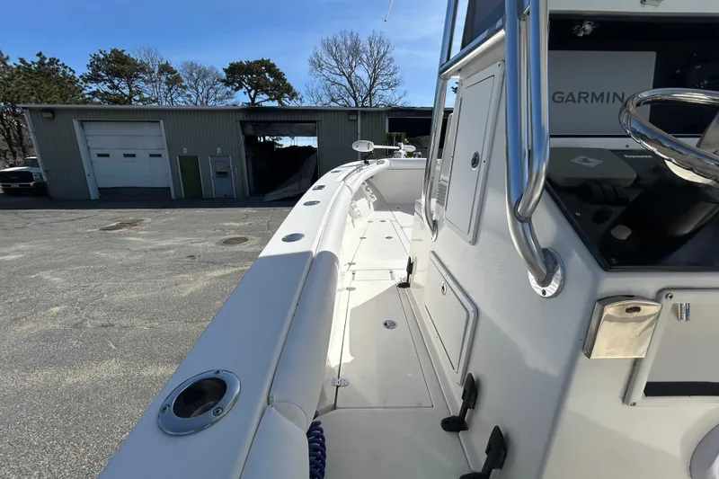 Slide: The Image of 2006 Albin 26 Center Console boat docked near a garage under clear blue sky. - 32