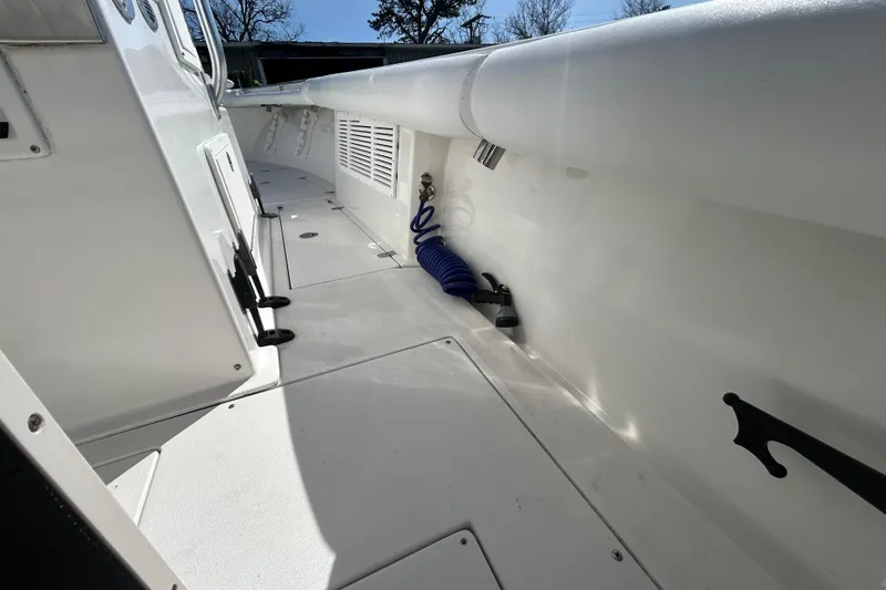 Slide: The Image of 2006 Albin 26 Center Console boat deck with storage compartments and coiled hose. - 34