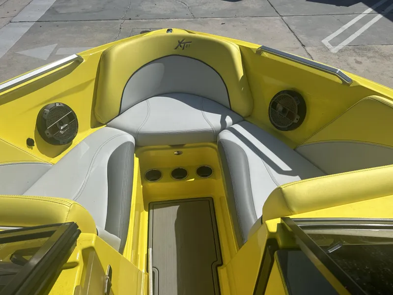Slide: The Image of Interior of a yellow 2021 MasterCraft XT21 boat with gray seating. - 10
