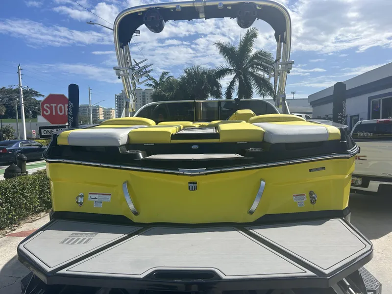Slide: The Image of Yellow 2021 MasterCraft XT21 boat parked outdoors. - 2