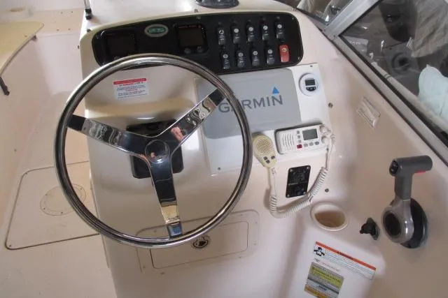 Slide: The Image of 2009 Grady-White Tournament 205 boat dashboard with steering wheel and Garmin equipment. - 2