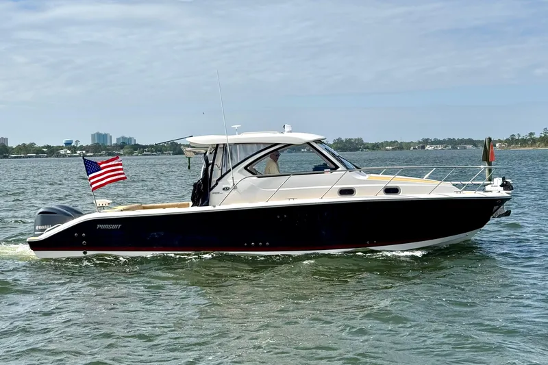 The Image of 2016 Pursuit OS 325 Offshore boat cruising on a sunny day with American flag. - 0