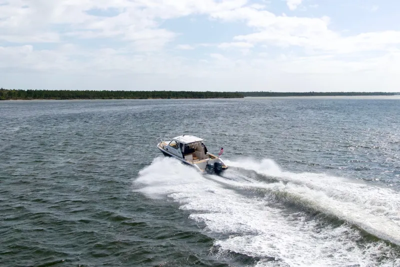 Slide: The Image of 2016 Pursuit OS 325 Offshore boat cruising on open water. - 11