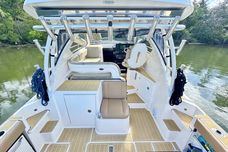 Slide: The Image of 2016 Pursuit OS 325 Offshore boat interior with seating and fishing rod holders. - 13