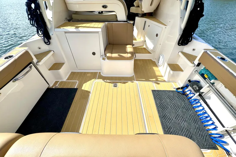 Slide: The Image of 2016 Pursuit OS 325 Offshore boat interior with tan seating and teak flooring. - 15