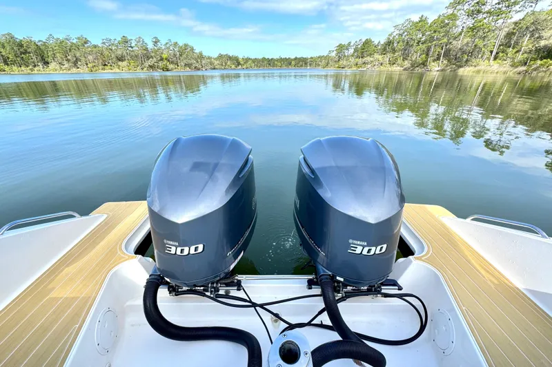 Slide: The Image of 2016 Pursuit OS 325 Offshore boat with twin Yamaha 300 engines on a serene lake. - 18