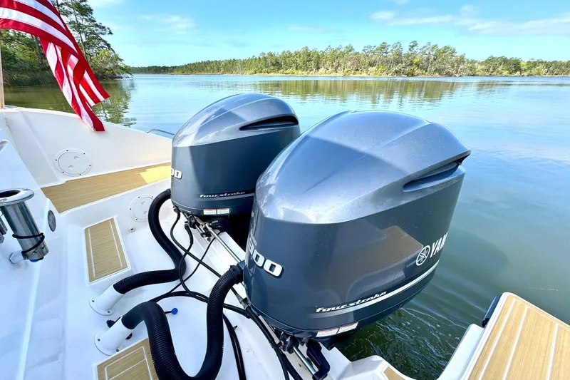 Slide: The Image of 2016 Pursuit OS 325 Offshore boat with twin Yamaha outboard motors on a serene lake. - 19