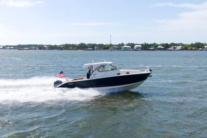 Slide: The Image of 2016 Pursuit OS 325 Offshore boat cruising on a sunny day with American flag. - 2