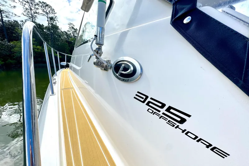 Slide: The Image of 2016 Pursuit OS 325 Offshore boat side view with logo and railing. - 24