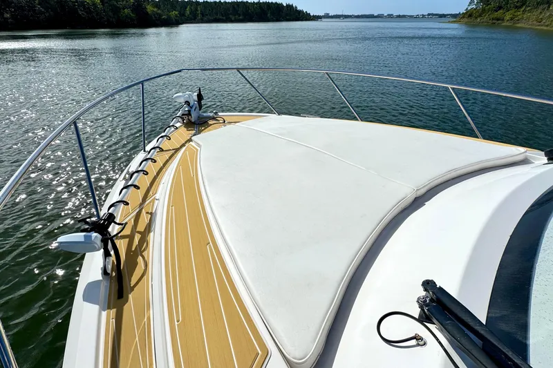 Slide: The Image of 2016 Pursuit OS 325 Offshore boat deck on calm water, featuring sleek design and spacious layout. - 25